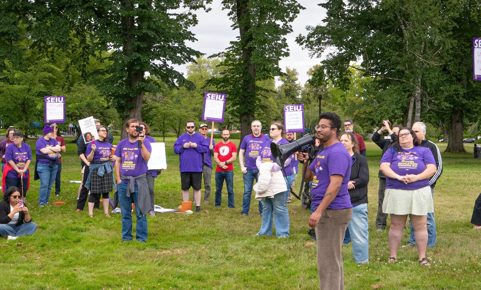 OSU bargaining delegate Damien Manassa addresses Local 083 members and supporters holding SEIU signs at McNary Field