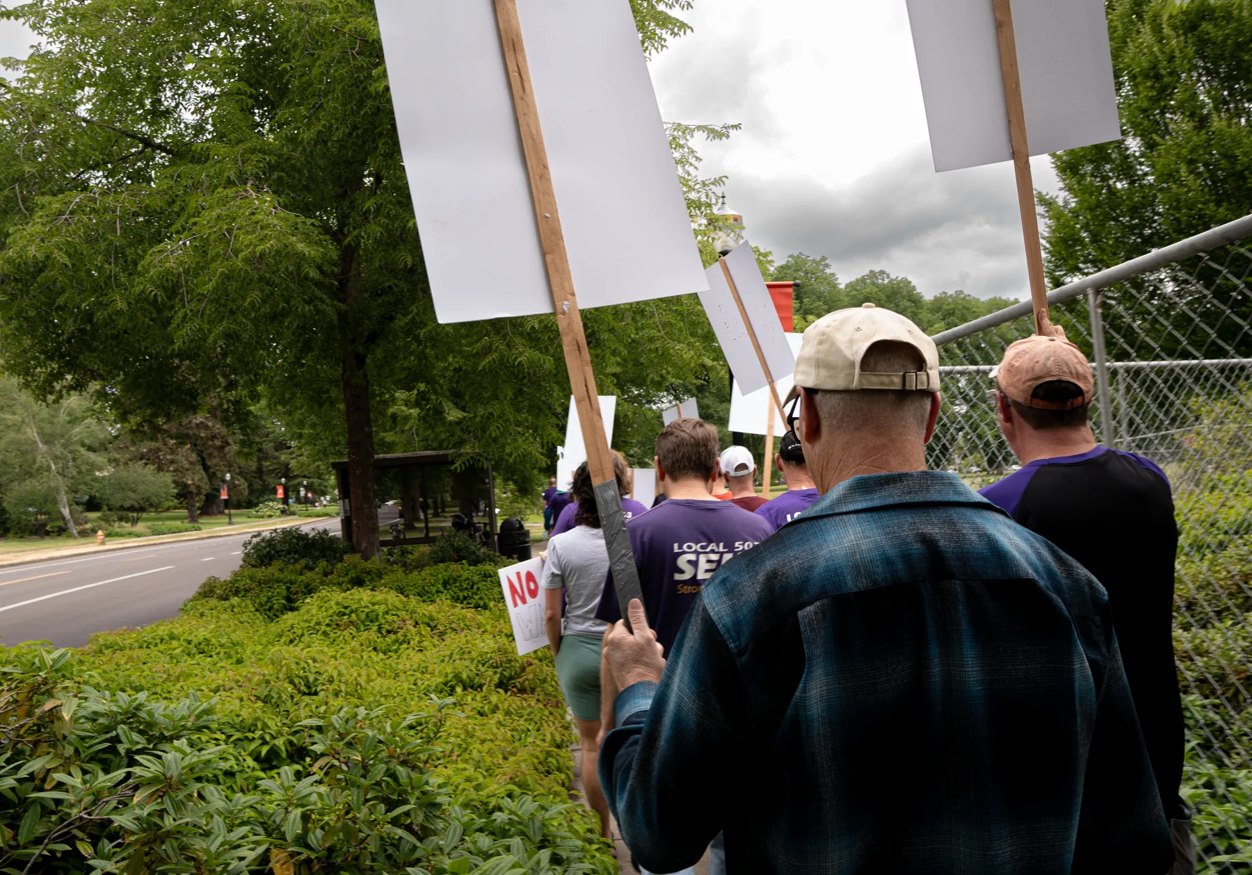 Local 083 members march toward Kerr Administration carrying rally signs