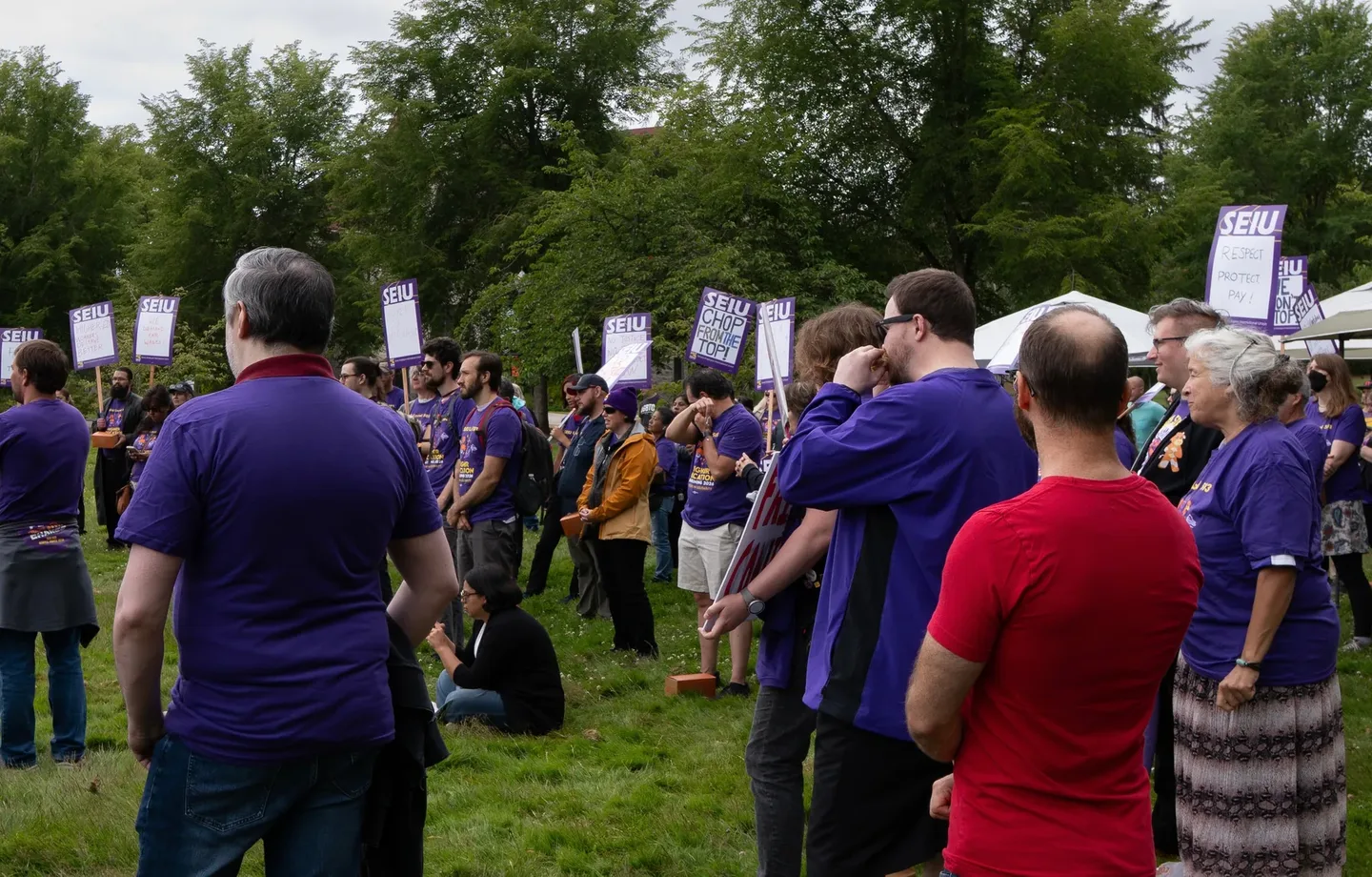 Local 083 members gathered at the June 30 rally with purple SEIU signs.