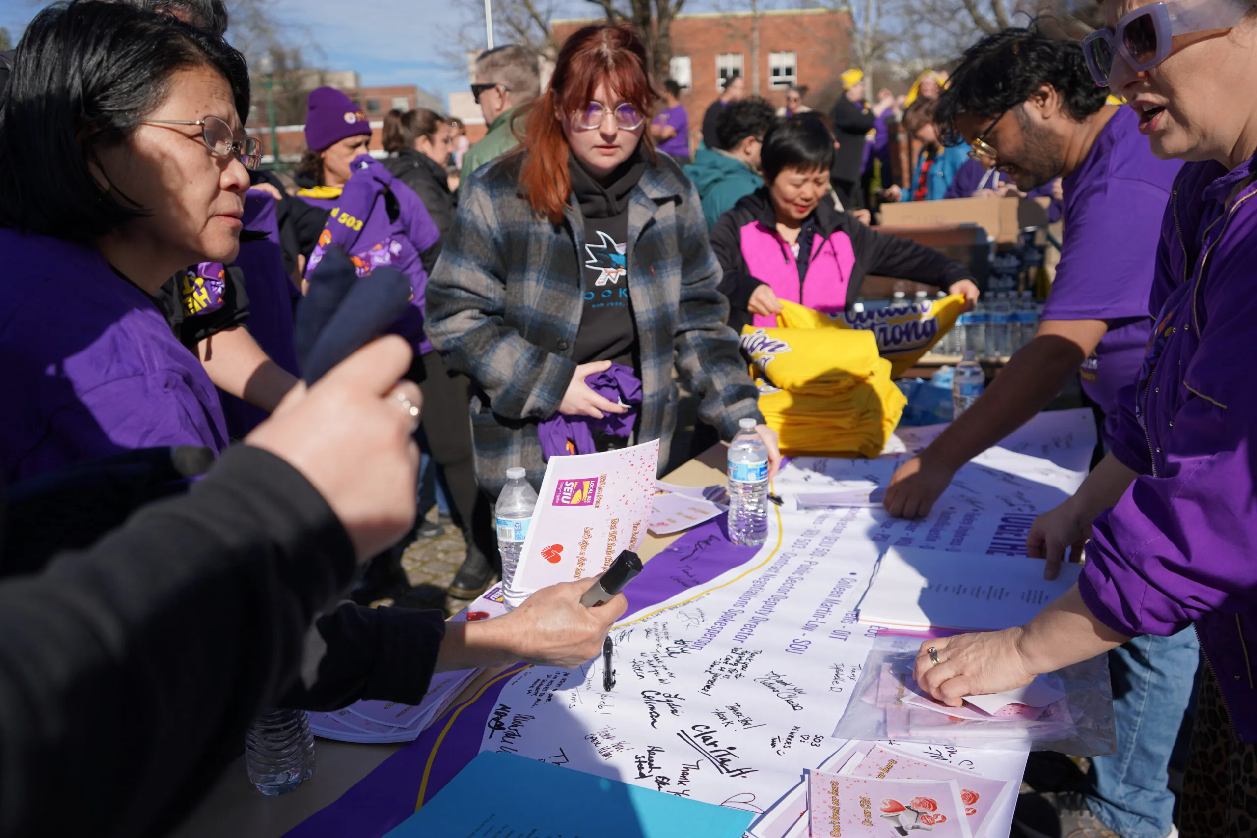Miembros firman una pancarta de San Valentín en apoyo de trabajadores de educación superior en la University of Oregon.